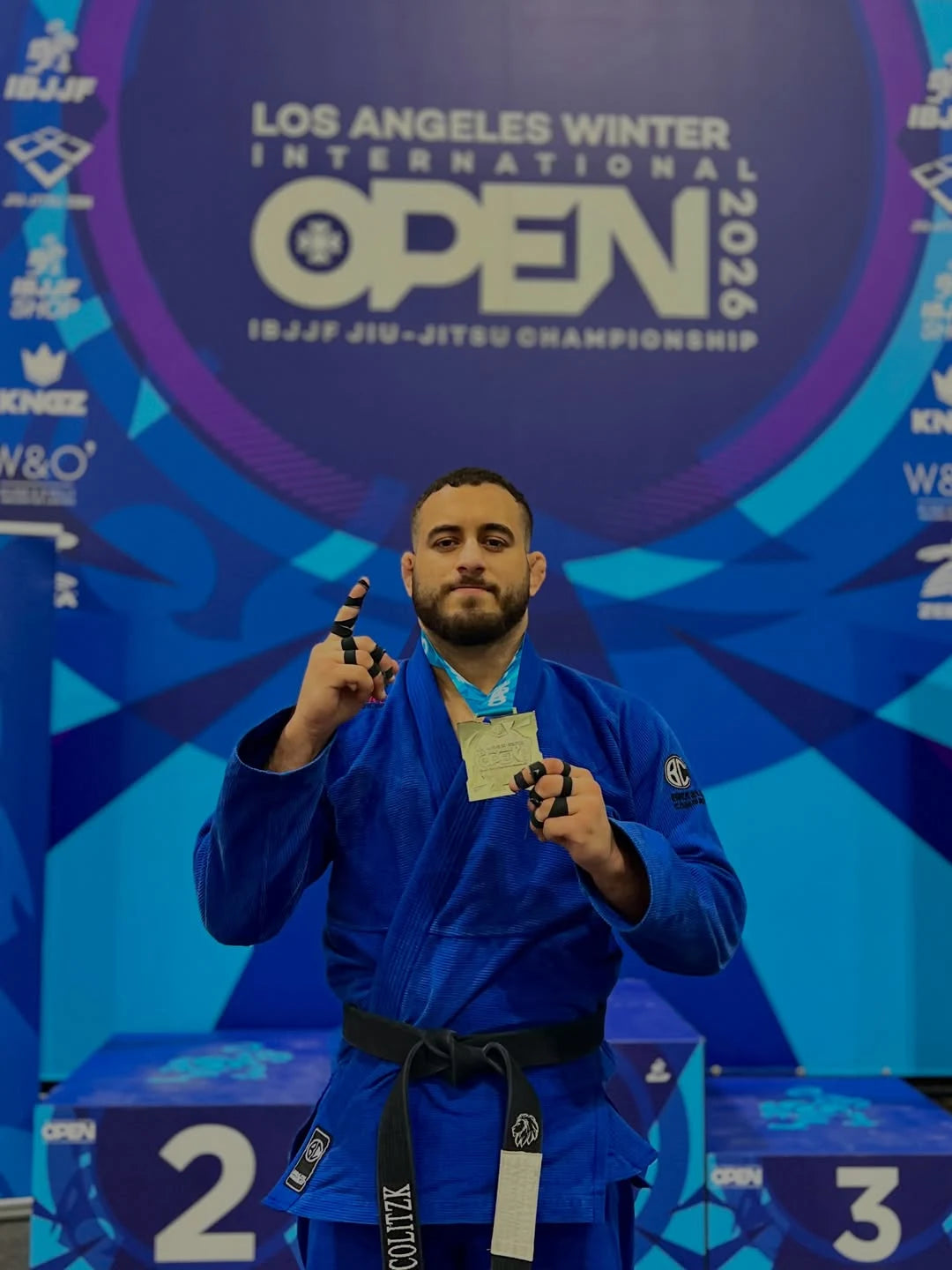 JOAO_PEDRO black belt stands on a podium at the 2026 IBJJF Jiu-Jitsu Championship in Los Angeles