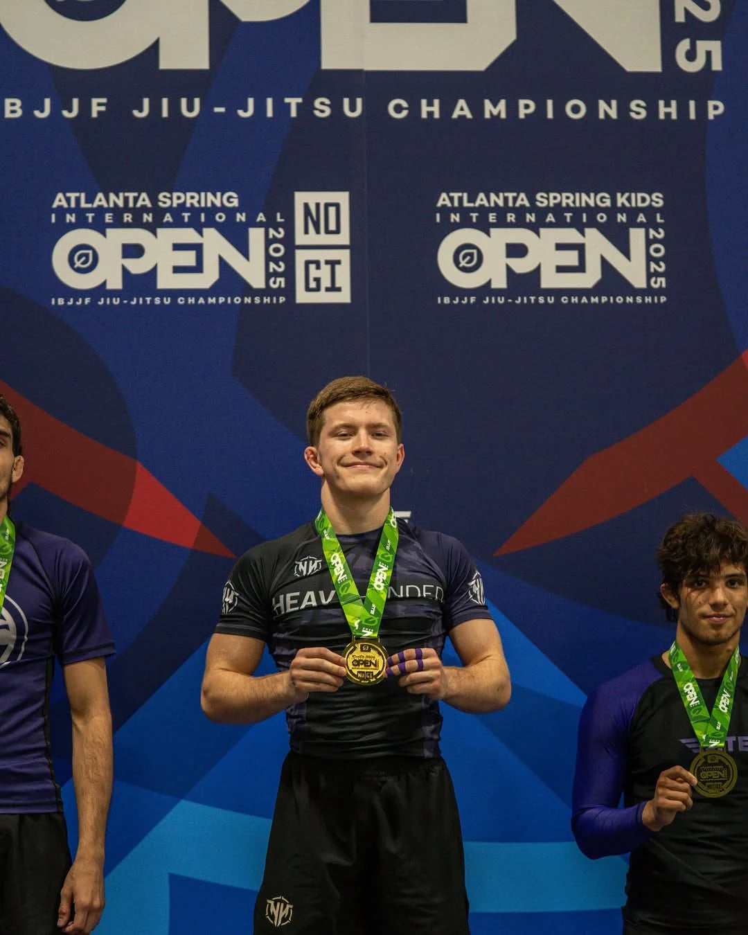 Joseph_Snyder stands on a podium holding a gold medal