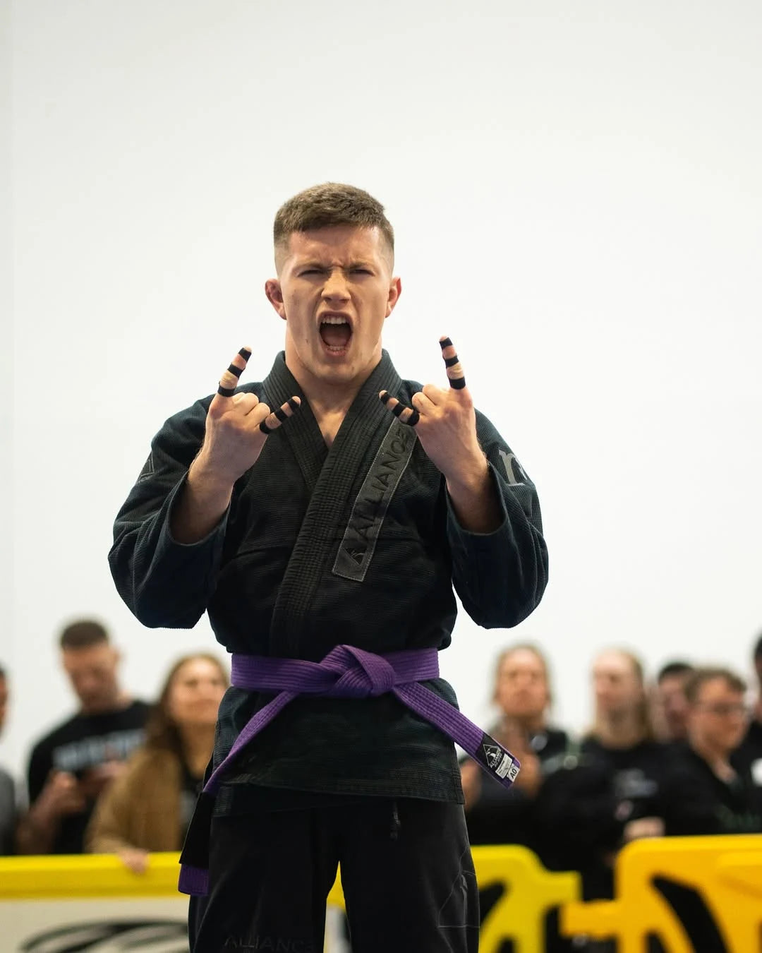 Joseph_Snyder Brazilian Jiu-Jitsu gi with a purple belt stands 