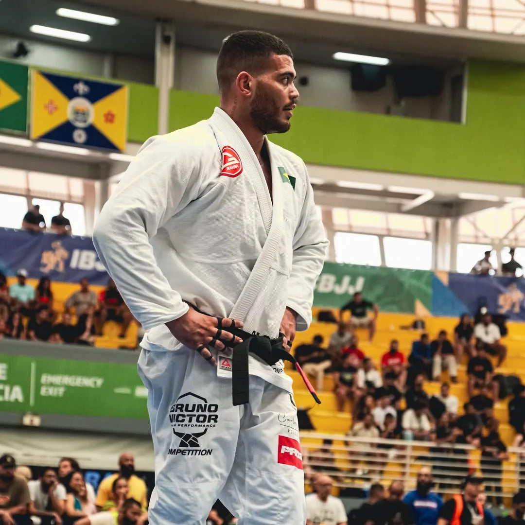 LUCAS_NORAT Brazilian Jiu-Jitsu gi stands on a competition floor .
